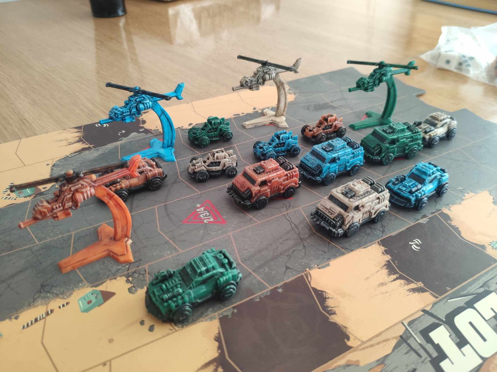 plastic helicopters and cars in various colors crowd a roadway that looks like it has seen better days