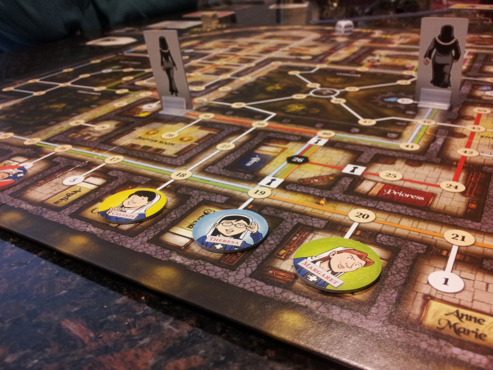 four novice tokens and two nun standees on a board of alls, doors, and numbered spaces connected by lines