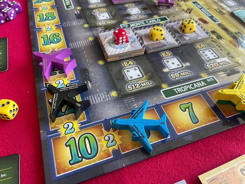 a board featuring a scoring track around the outside, dice spaces on the inner part, and airplanes on the score track